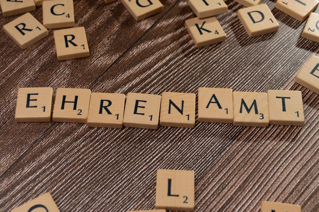Scrabble tiles spelling 'Ehrenamt' on a wooden background. Perfect for volunteerism themes.